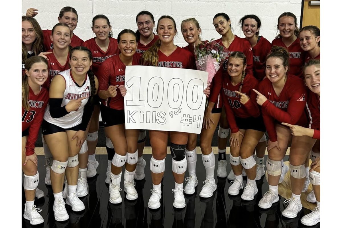 Volleyball standout Regan Bruggerman  with teammates after her milestone moment. 