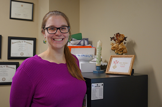 Dr. Sarah Harris stands beside the tangible reminders of her faith journey.