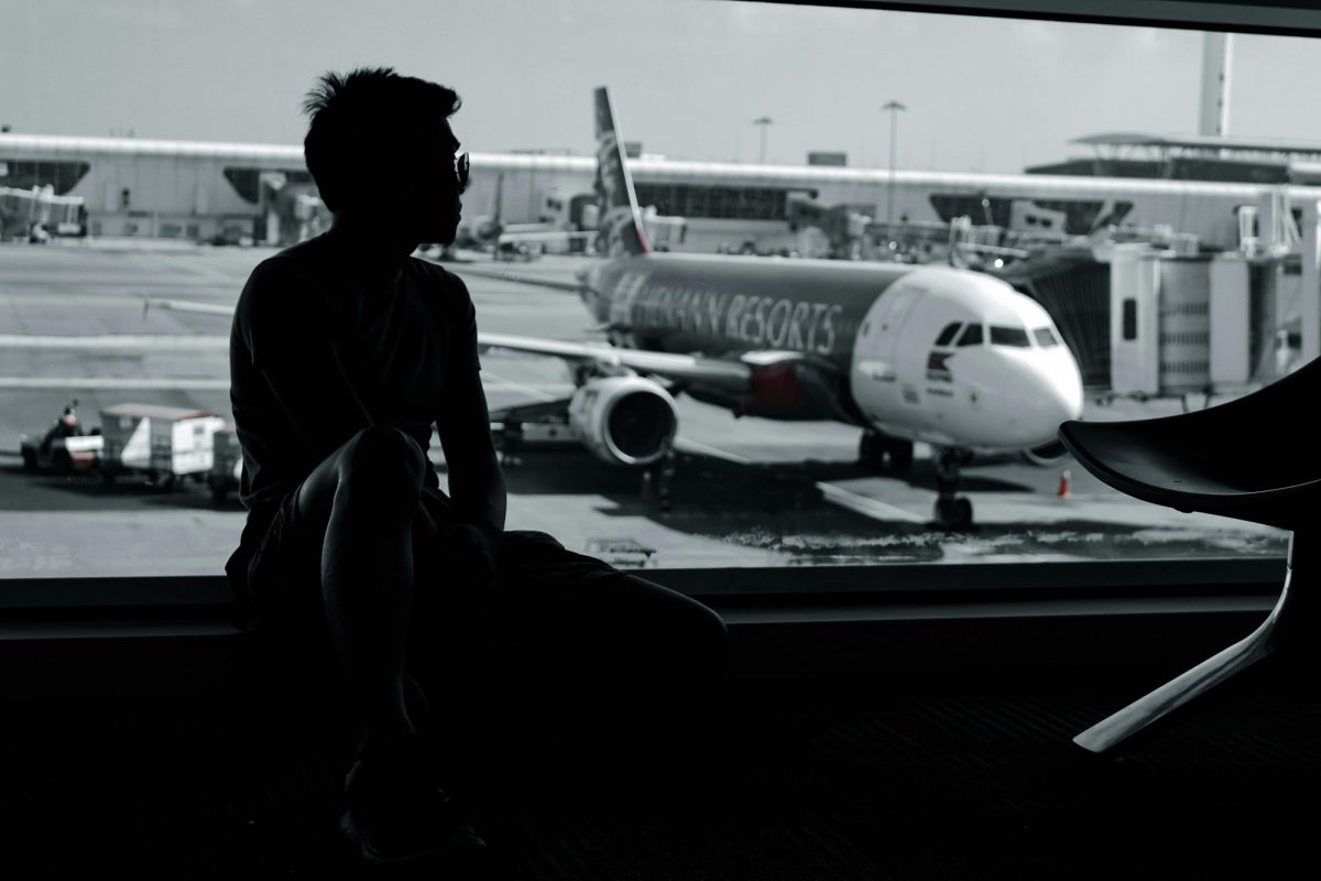 Man Sitting on a Window in an Airport Waiting Room 