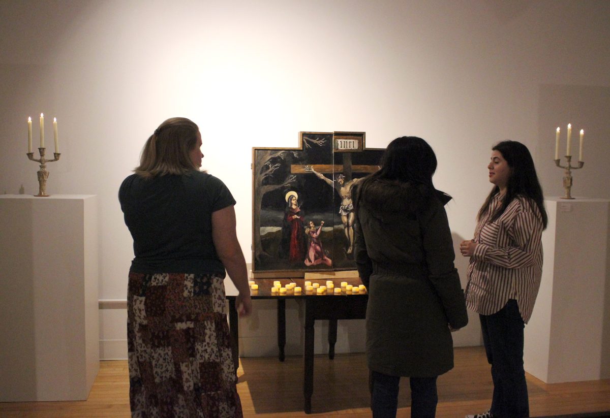 Left to right: Allie Matthews, Maddie Cassidy and Camille Carrillo Salado admire a painted altarpiece created by Alondra Gomez, a highlighted work of her exhibition. 