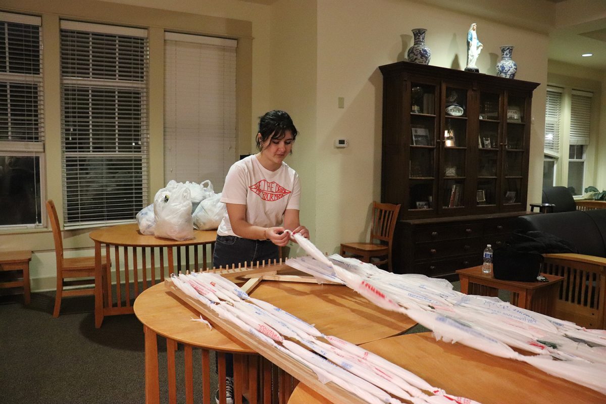 A student weaves sleeping mats for the homeless during Social Justice Week.